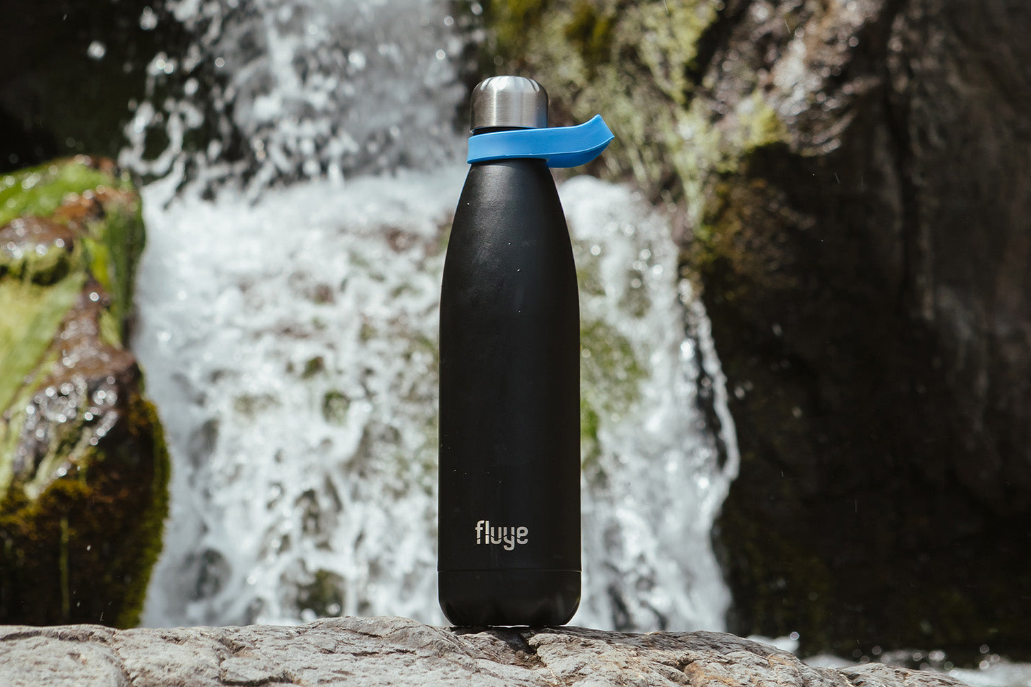 Image of Botella Fluye frente a una catarata.